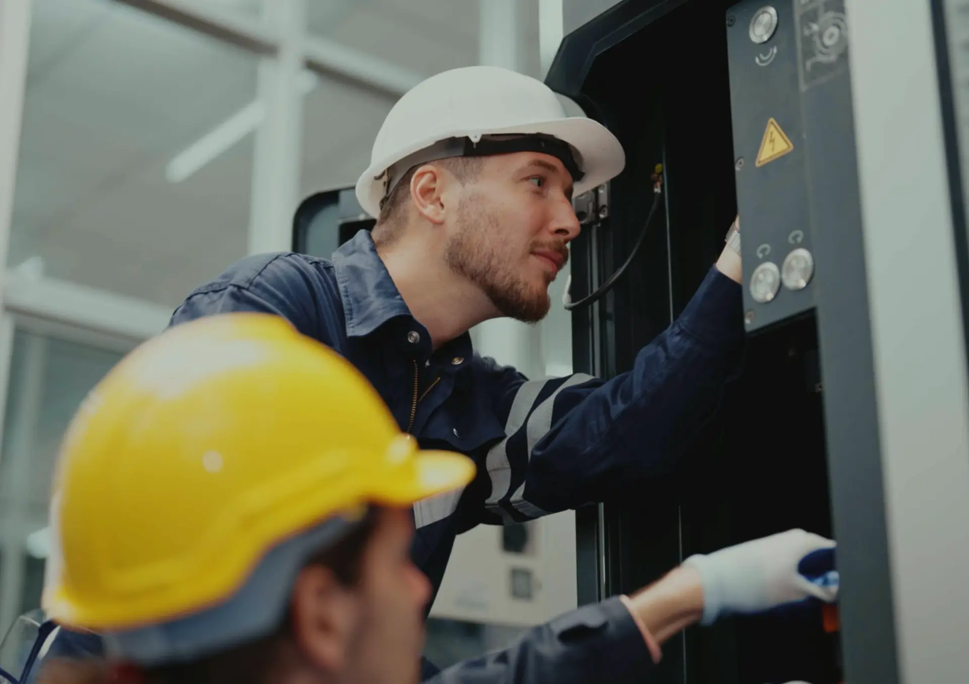 An electrical contractor working on a control panel, used as an industry example for professional electrician web design services in Armagh.